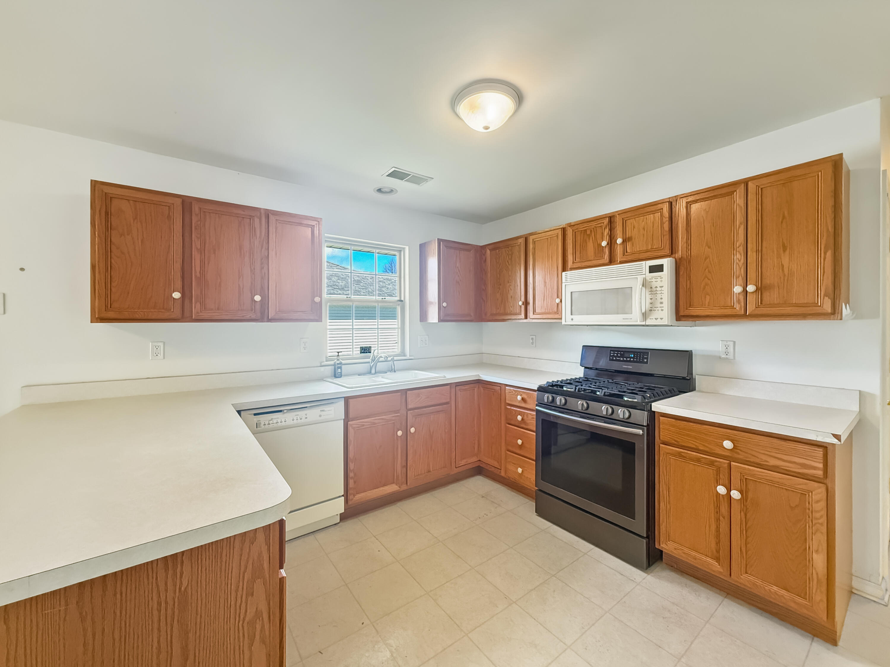 2962 Liberty Drive Crown Point, IN 46307 - Photo 5 of 18 a kitchen with stainless steel appliances granite countertop a stove top oven a sink dishwasher and a refrigerator with wooden cabinets