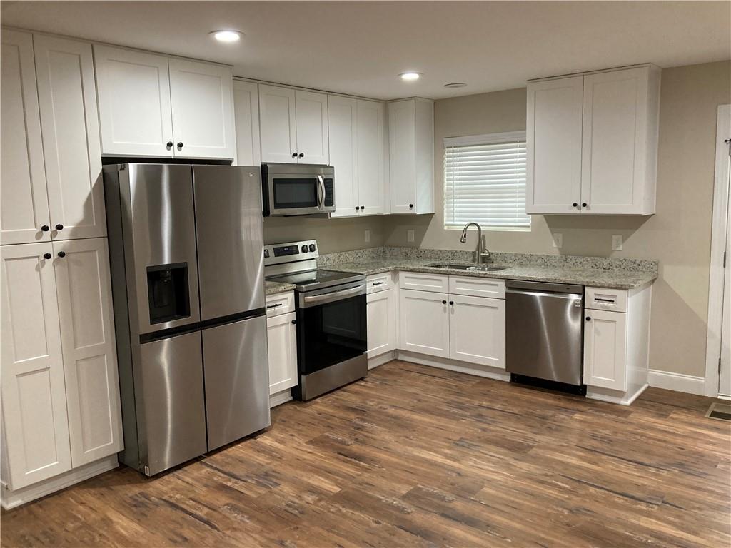 3780 Highway 52 Dahlonega, GA 30533 - Photo 5 of 19 a kitchen with stainless steel appliances granite countertop a refrigerator stove a sink and white cabinets