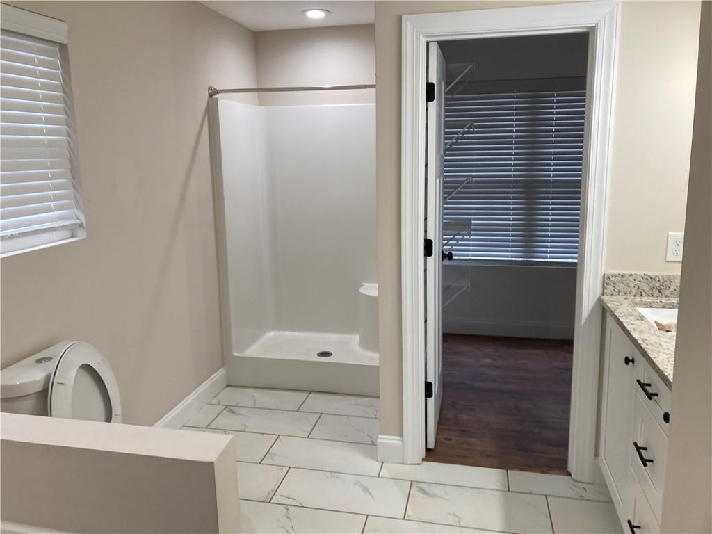 3780 Highway 52 Dahlonega, GA 30533 - Photo 9 of 19 a bathroom with a granite countertop sink a toilet and shower