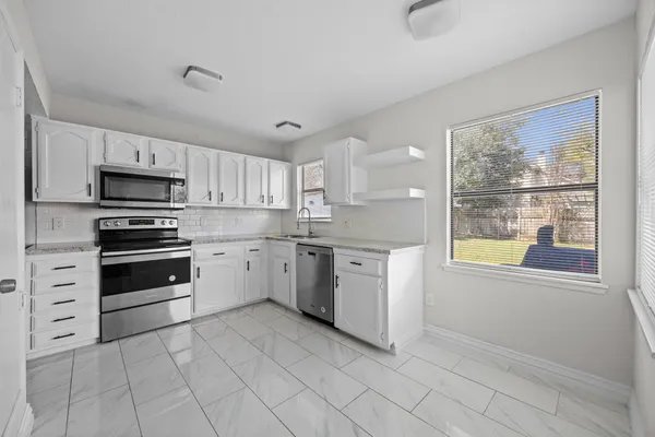 a kitchen with cabinets appliances and a window