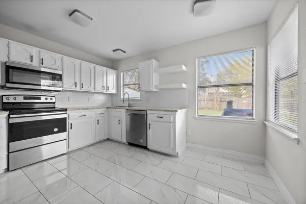 a kitchen with a stove a sink and a window