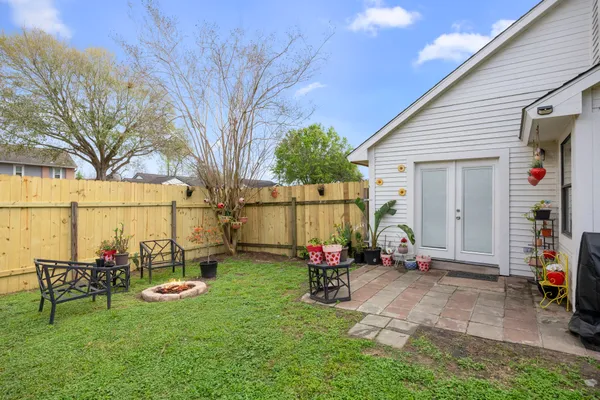 a view of backyard with wooden fence and a large tree