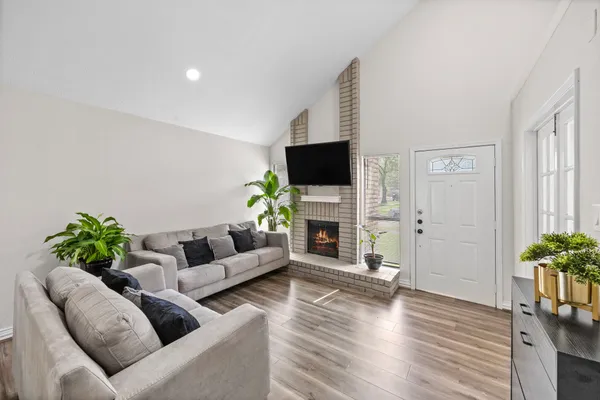 a living room with furniture a fireplace and a flat screen tv