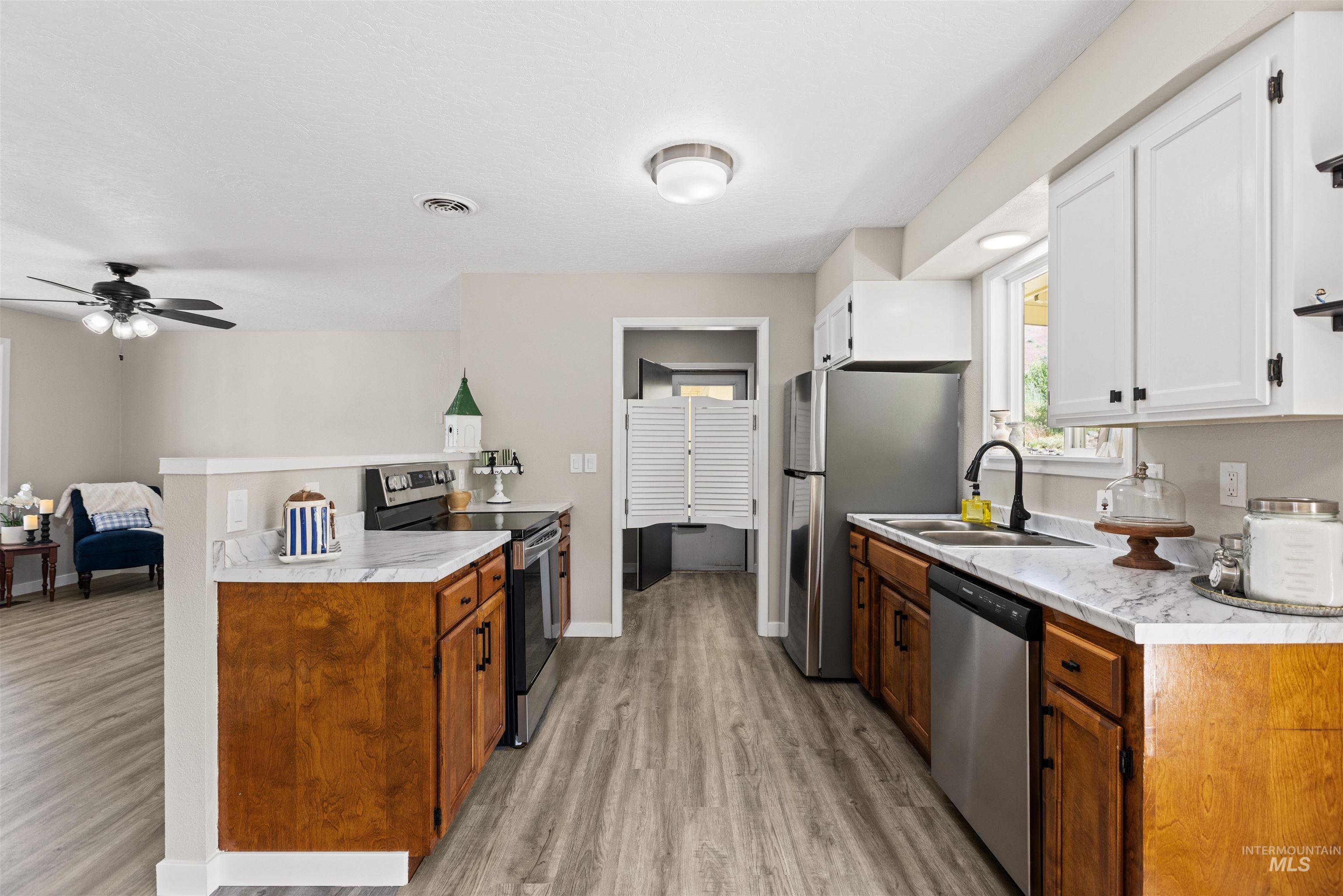12184 Hill Road Payette, ID 83661 - Photo 13 of 35 Kitchen featuring L-shaped counter space with stone-finish countertops, stainless steel appliances, and wood-finish lower cabinetry