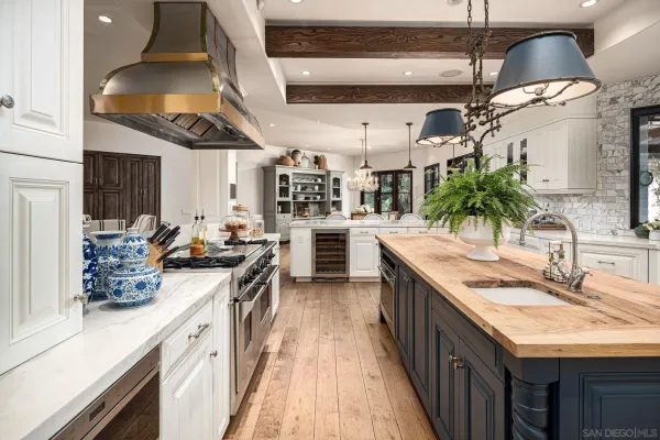 a kitchen with stainless steel appliances kitchen island granite countertop a refrigerator a stove and a wooden floors