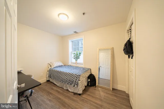 a bedroom with a bed and wooden floor