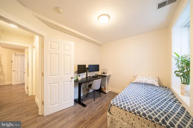 a bedroom with a bed and wooden floor