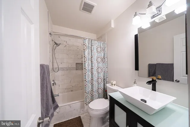 a bathroom with a sink a toilet a mirror and shower