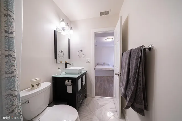 a bathroom with a toilet sink and mirror