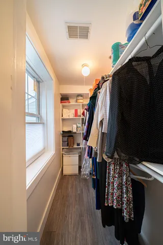 a view of walk in closet with clothes and shoes