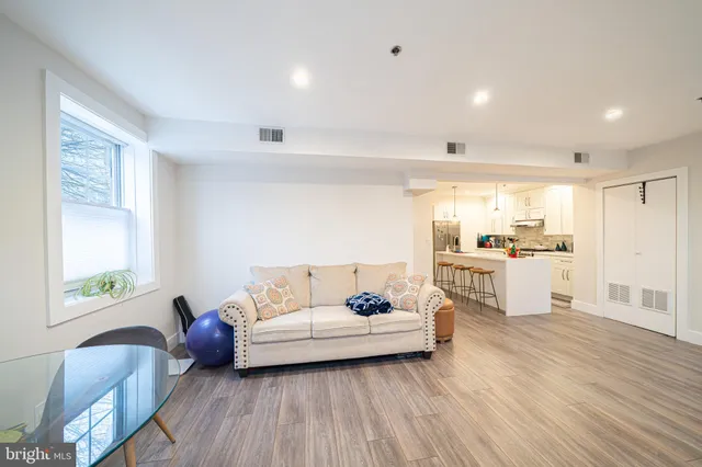 a living room with furniture and a large window with wooden floor