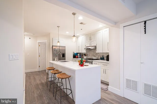 a kitchen with a sink a stove a refrigerator and white cabinets