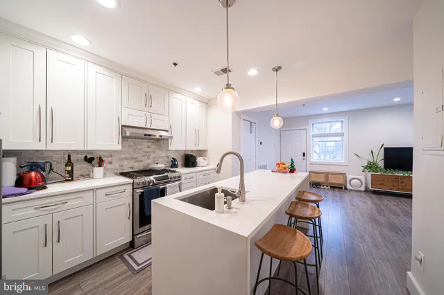 a kitchen that has a lot of cabinets a sink and appliances in it