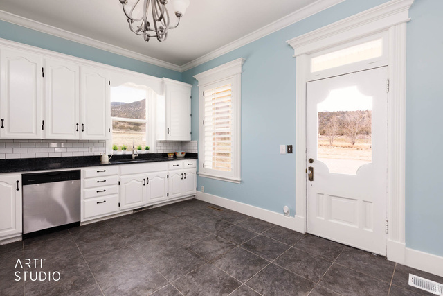1331 South Lowry Hl Road Manti, UT 84642 - Photo 25 of 56 Kitchen with stainless steel dishwasher, white cabinets, ornamental molding, hanging lights, and tasteful backsplash