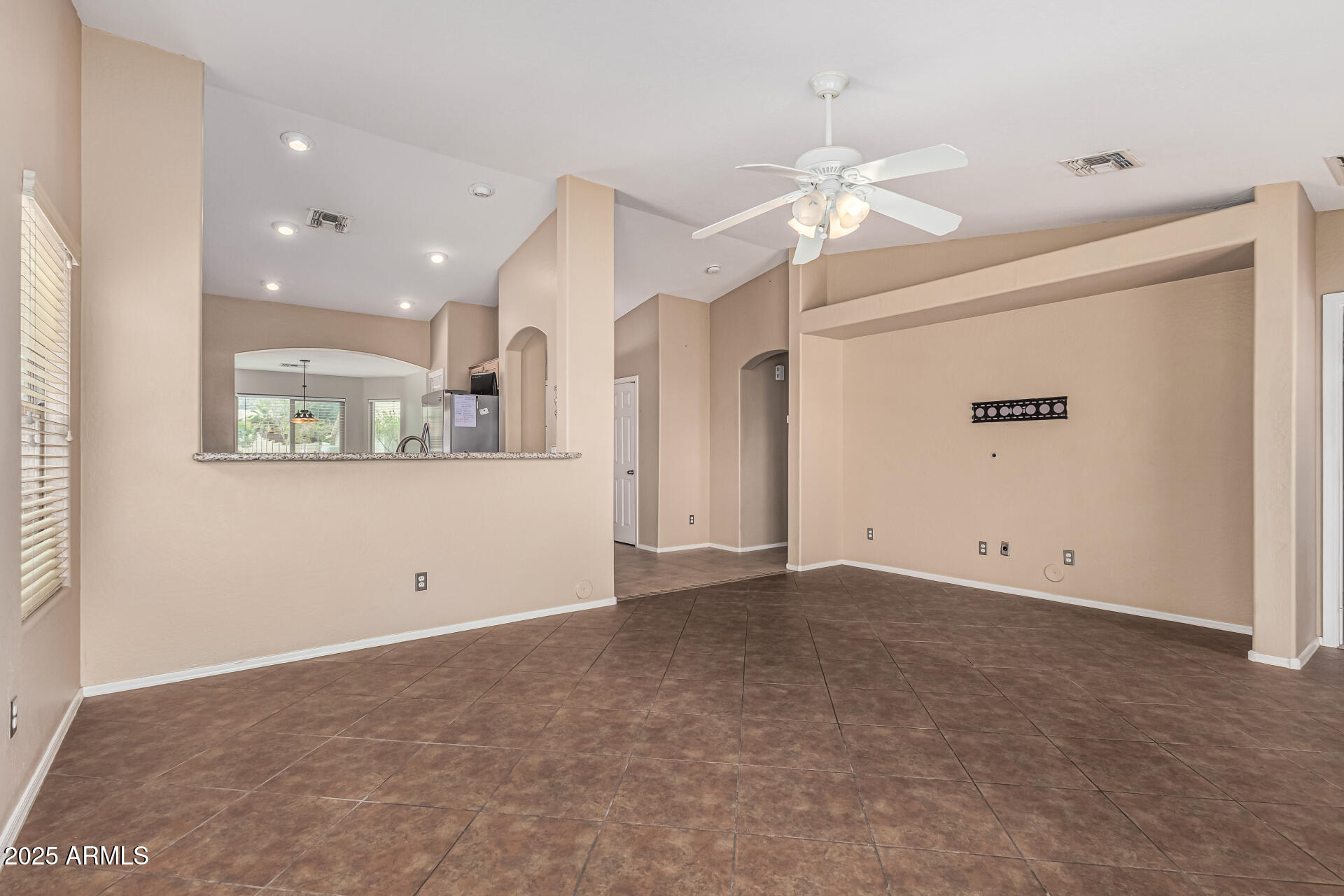 1634 East Harwell Road Phoenix, AZ 85042 - Photo 6 of 44 an empty room with a ceiling fan and a window