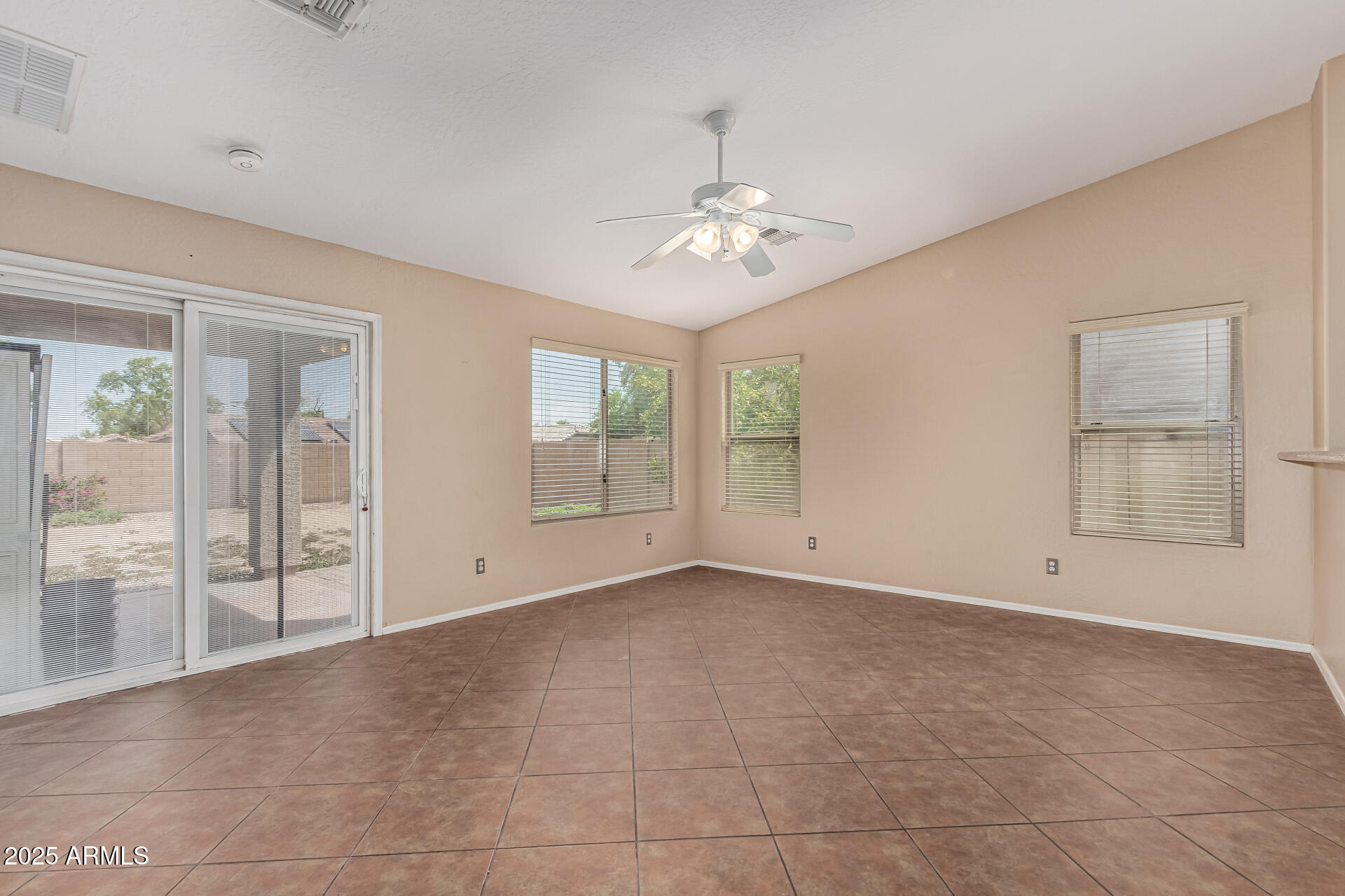 1634 East Harwell Road Phoenix, AZ 85042 - Photo 7 of 44 an empty room with chandelier fan and windows