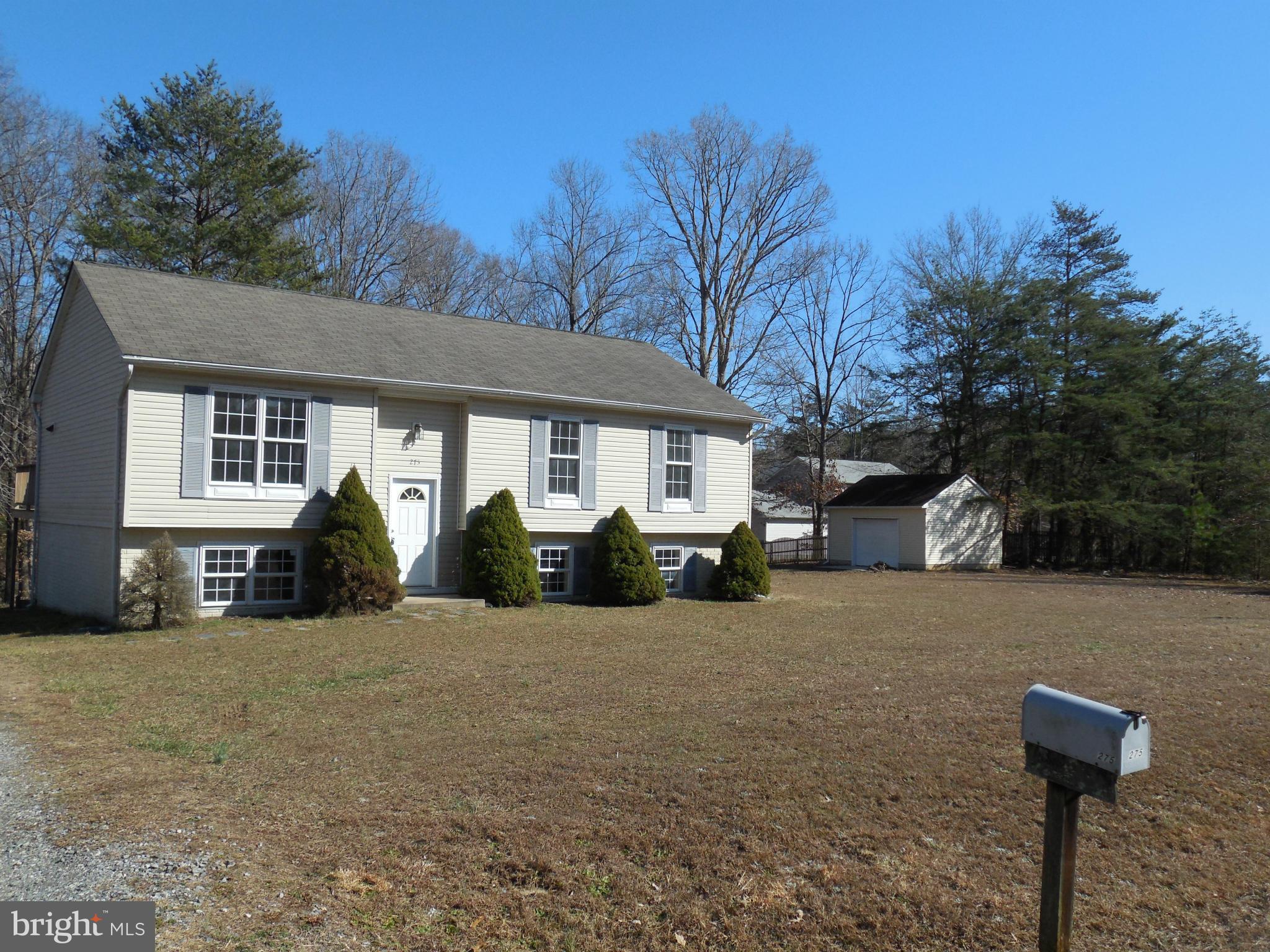 275 Cedar Ridge Drive Ruther Glen, VA 22546 - Photo 2 of 25 a front view of a house with a yard and garage
