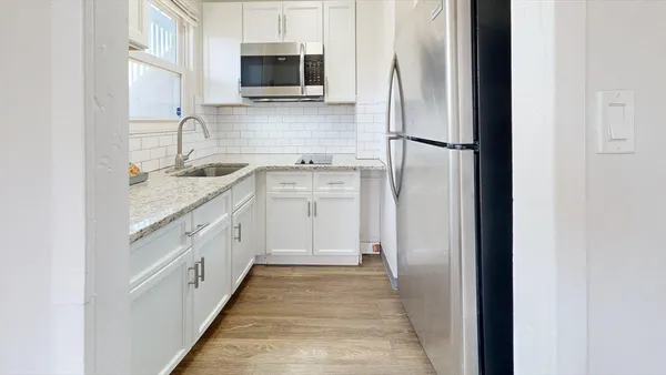 a kitchen with stainless steel appliances granite countertop a refrigerator and a sink