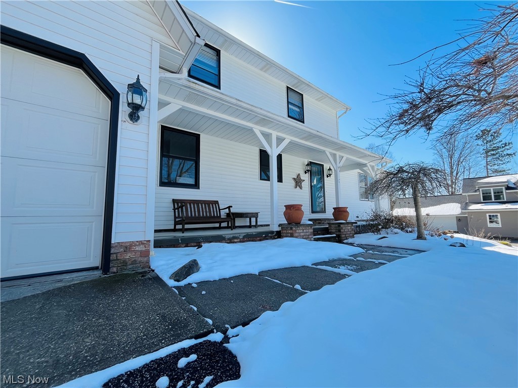 13655 Spring Street Burton, OH 44021 - Photo 2 of 48 Snow covered property entrance with a garage and covered porch