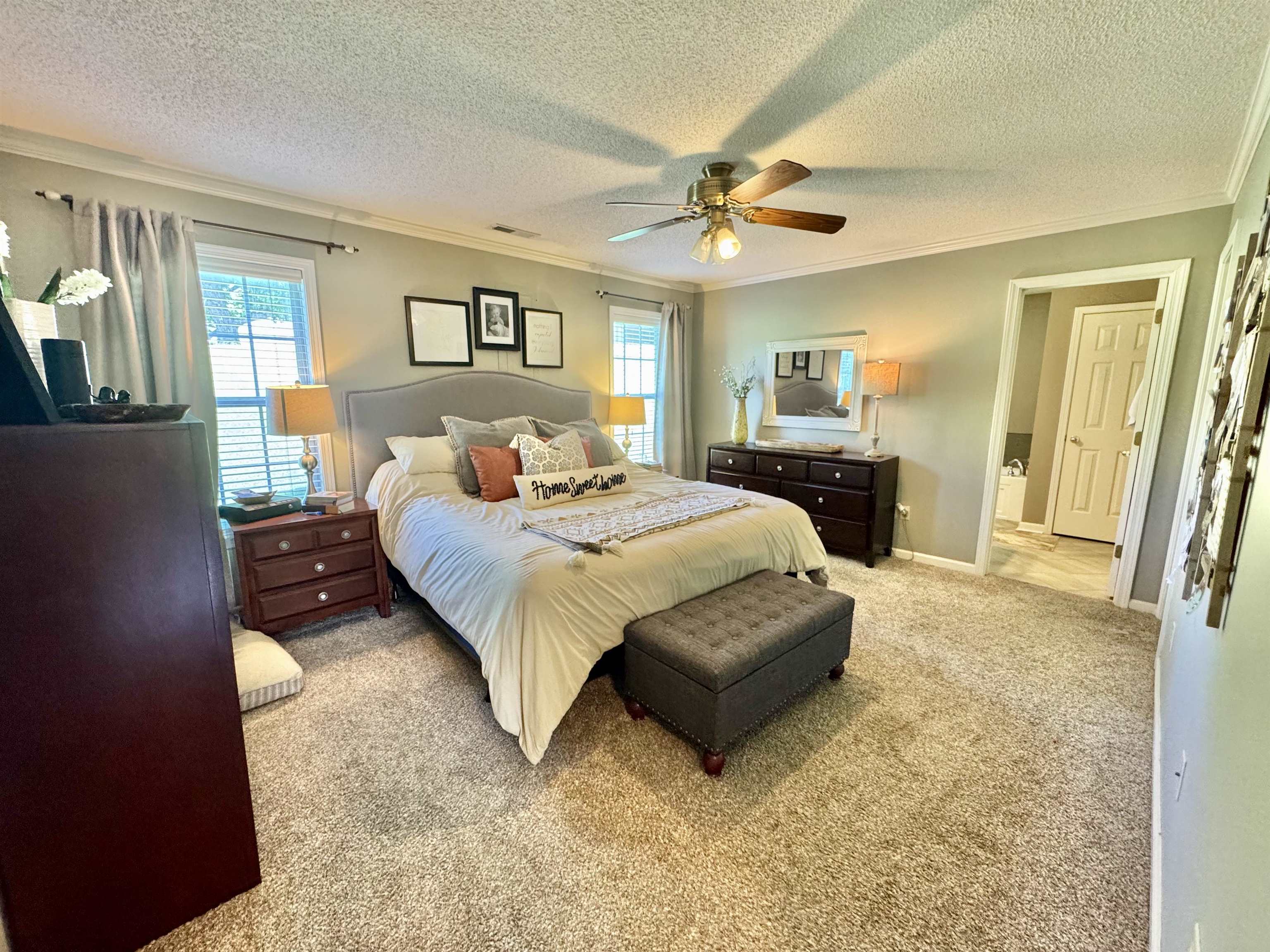 150 Westwood Circle Ripley, TN 38063 - Photo 11 of 28 Bedroom with ornamental molding, multiple windows, light carpet, a textured ceiling, and a ceiling fan