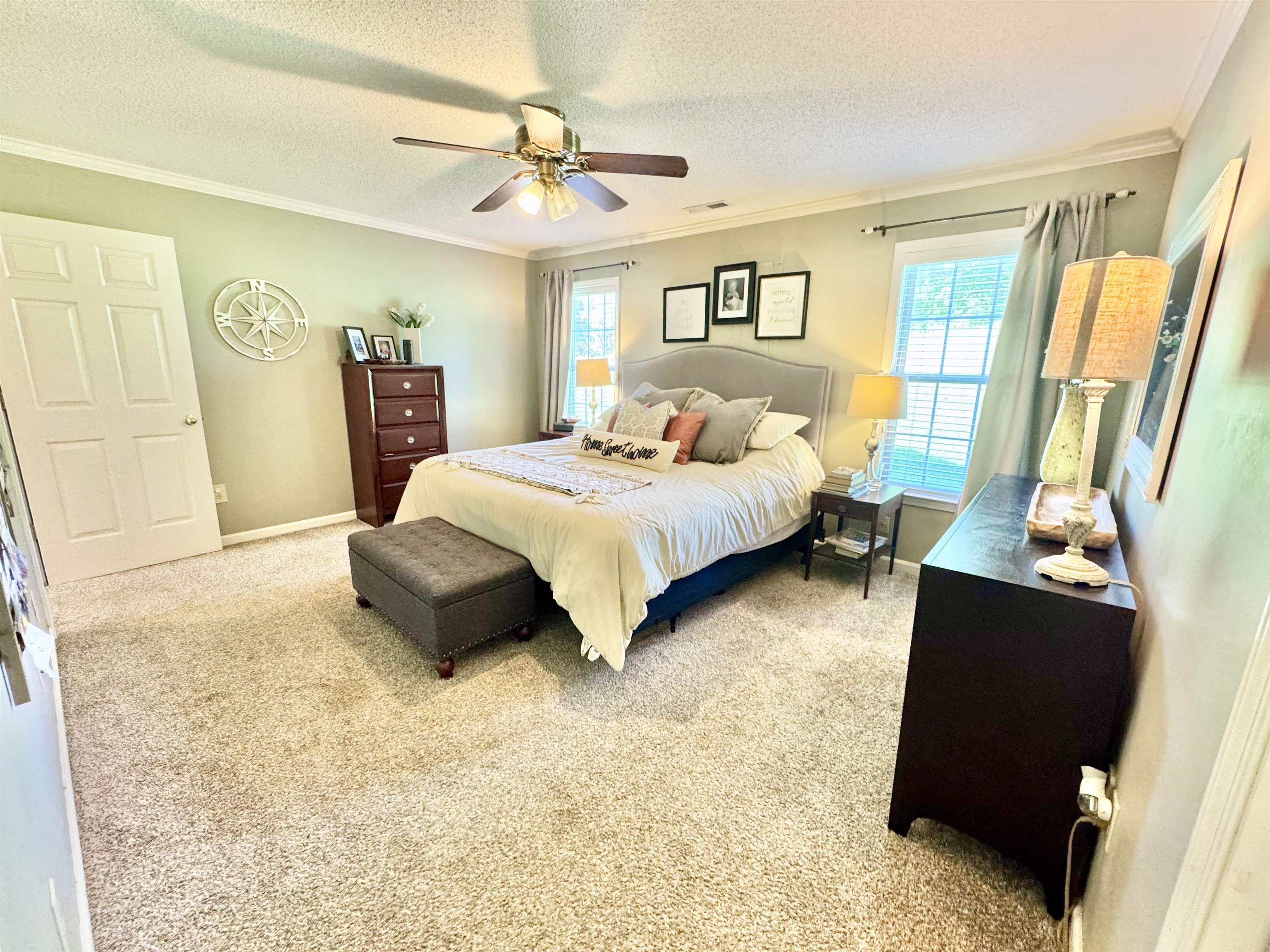 150 Westwood Circle Ripley, TN 38063 - Photo 12 of 28 Bedroom with multiple windows, ornamental molding, light colored carpet, a textured ceiling, and a ceiling fan