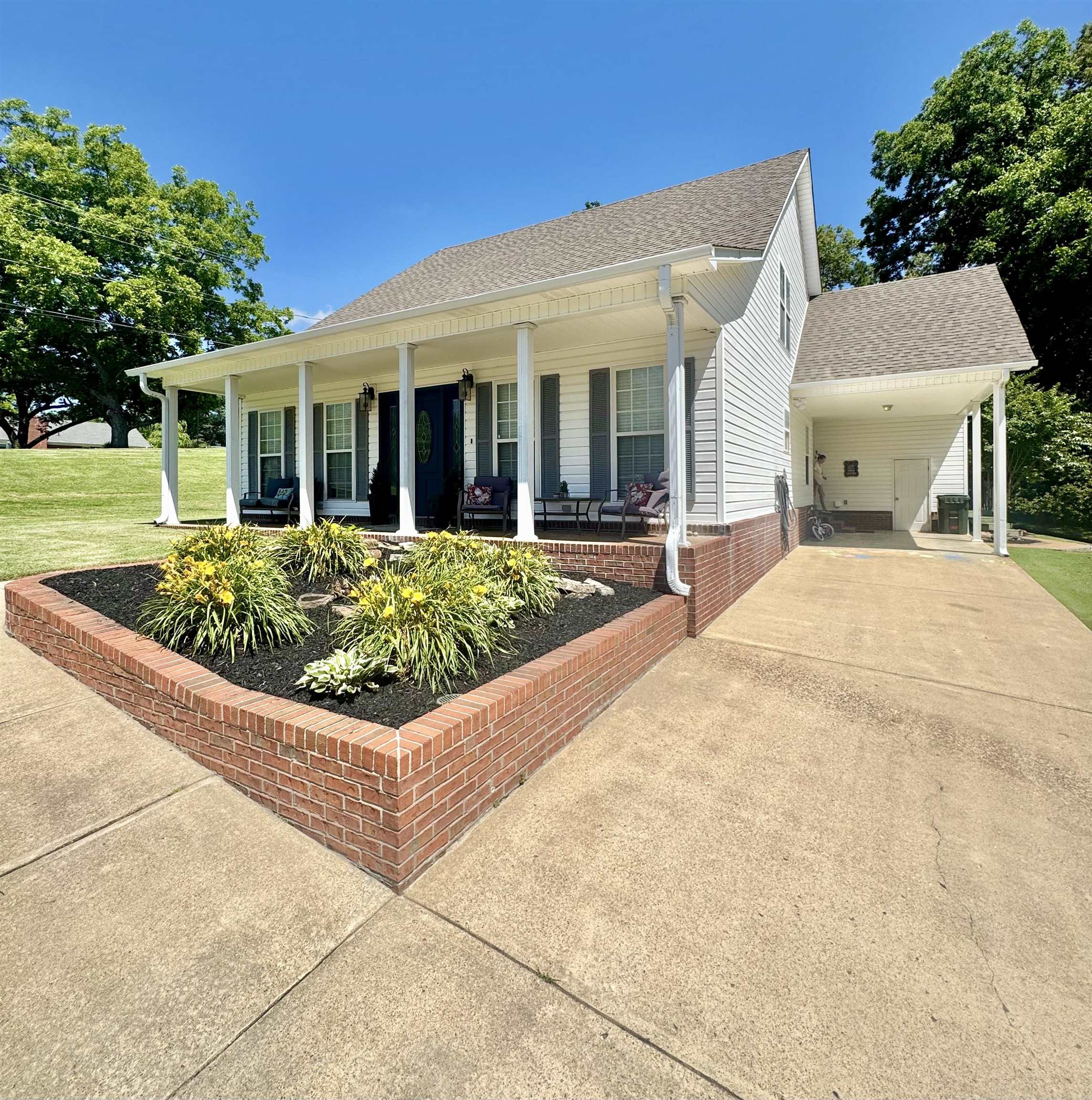 150 Westwood Circle Ripley, TN 38063 - Photo 3 of 28 Single story home with covered porch, concrete driveway, an attached carport, a shingled roof, and a front lawn
