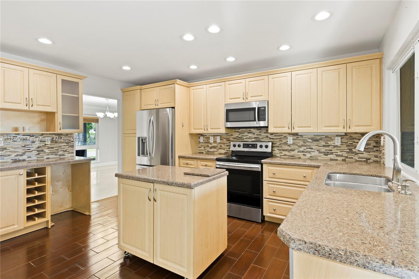 6150 Southwest 7th Street Plantation, FL 33317 - Photo 11 of 50 a kitchen with kitchen island granite countertop a stove sink and cabinets