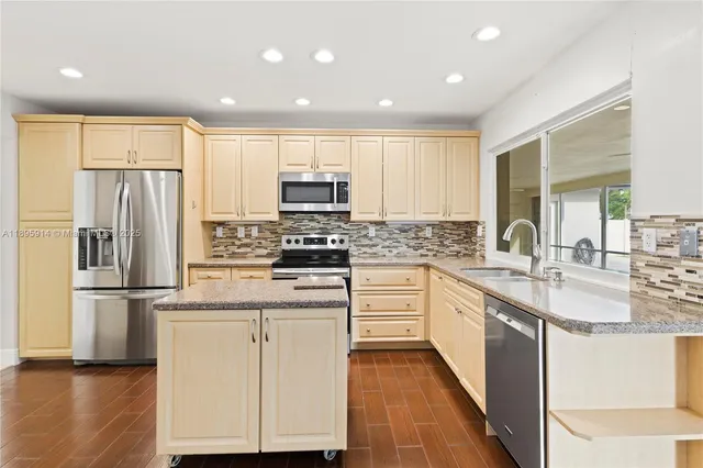 a kitchen with kitchen island granite countertop a stove and a refrigerator
