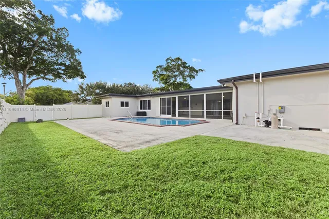 a view of backyard with swimming pool and seating area