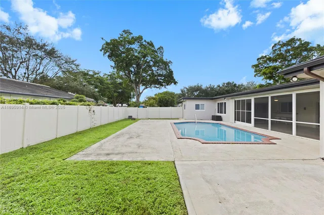 a view of a house with a big yard and large trees