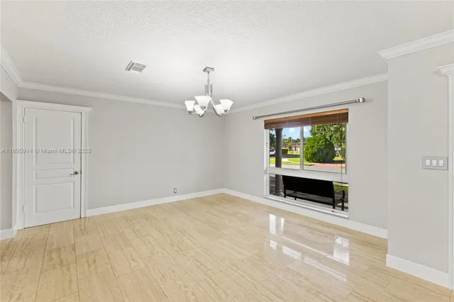 a view of a livingroom with a chandelier fan and a window