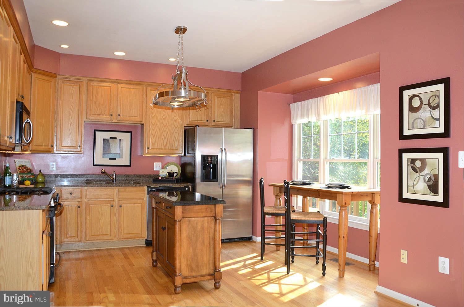1267 Weatherstone Court Reston, VA 20194 - Photo 10 of 30 a kitchen with refrigerator a sink and chairs