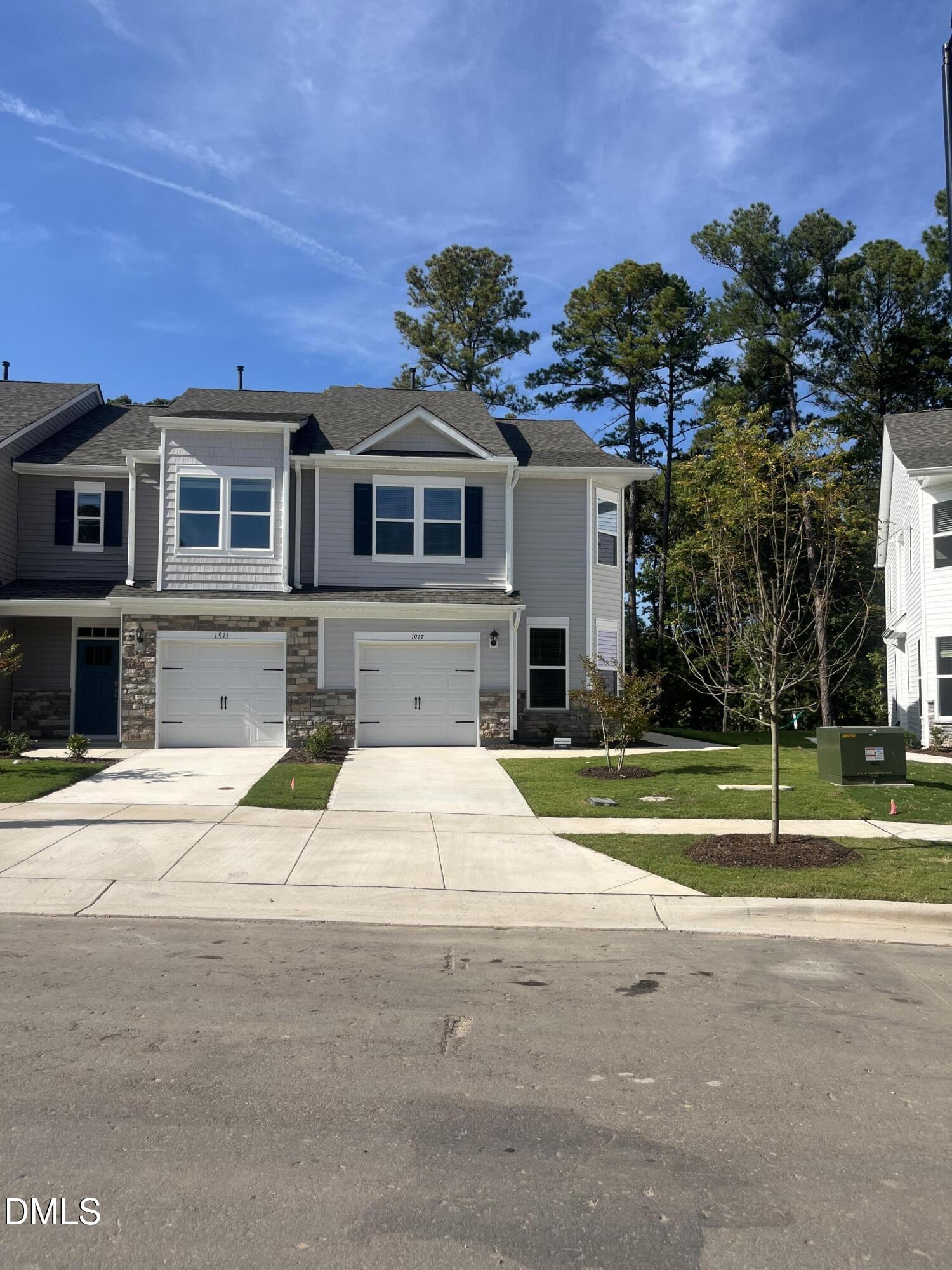 a front view of a house with a yard and potted plants