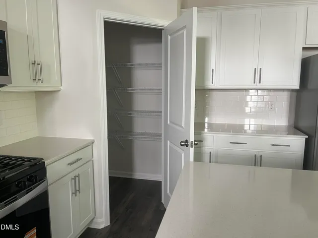 a kitchen with white cabinets and white appliances