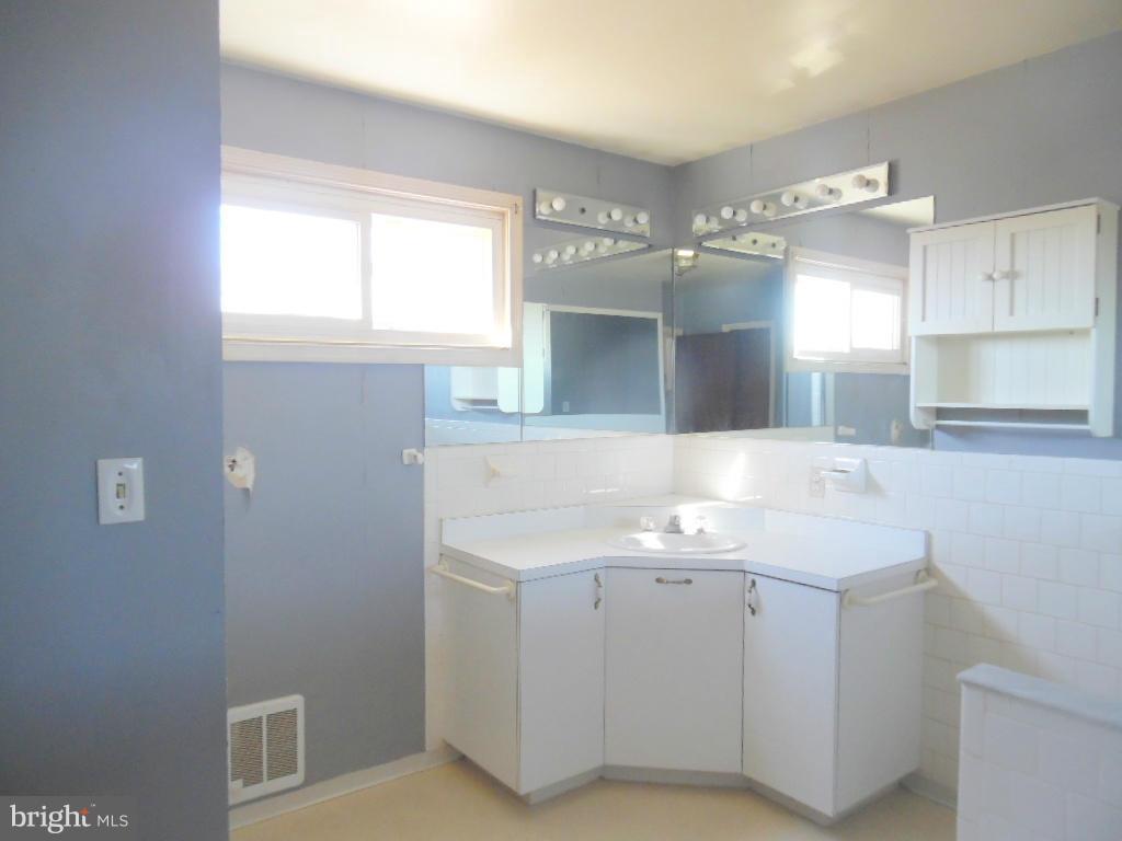 2422 Plainfield Road Dundalk, MD 21222 - Photo 12 of 14 a bathroom with a sink a vanity and mirror