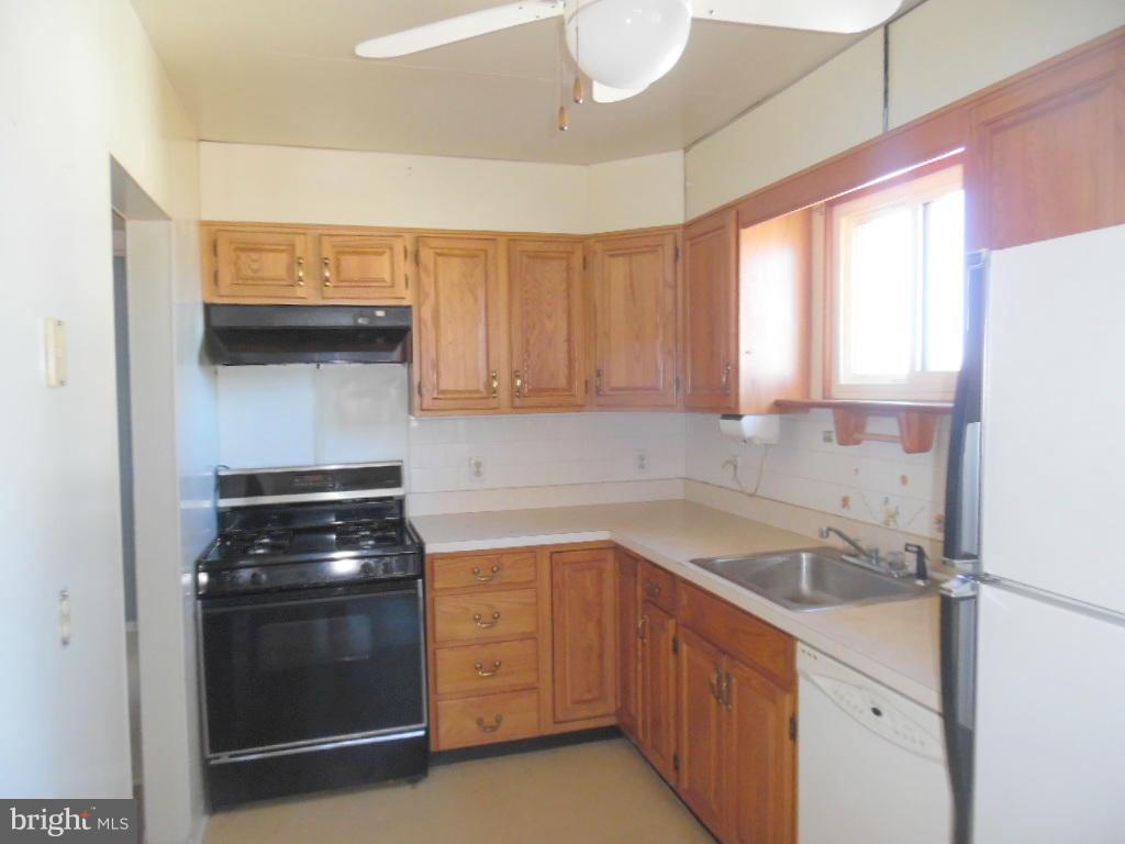 2422 Plainfield Road Dundalk, MD 21222 - Photo 9 of 14 a kitchen with a sink stove and cabinets