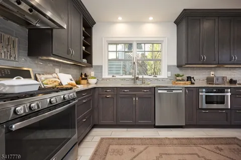 a kitchen with stainless steel appliances kitchen island granite countertop a sink cabinets and wooden floor
