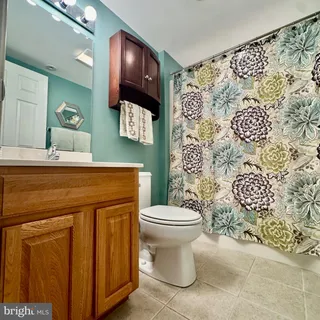 a white toilet sitting next to a bathroom sink and vanity