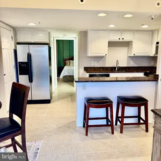 a kitchen with stainless steel appliances kitchen island granite countertop furniture and a refrigerator
