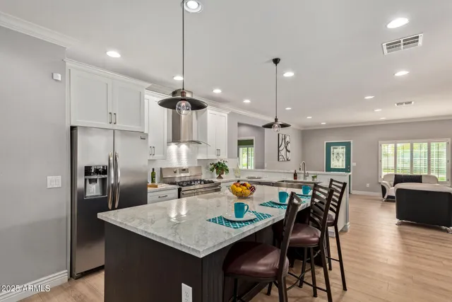 a view of a dining room and livingroom with furniture wooden floor a chandelier