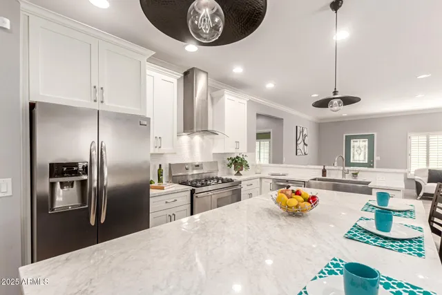 a kitchen with stainless steel appliances granite countertop a sink a stove and a refrigerator