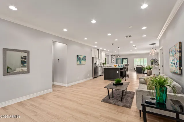 a living room with furniture and a dining table with wooden floor