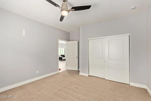 an empty room with closet and fan