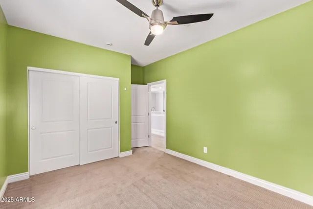 an empty room with a ceiling fan and a window