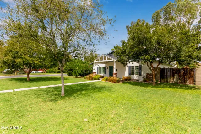 a view of a house with a big yard and large trees
