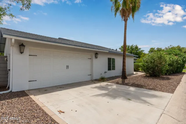 a view of a house with a yard and potted plants
