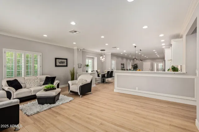 a living room with furniture wooden floor and a large window