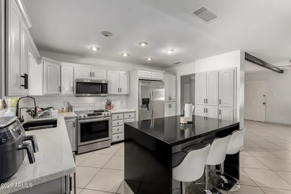 a kitchen with stainless steel appliances granite countertop a stove a sink a microwave and a refrigerator