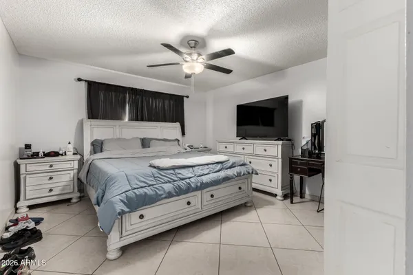 a bedroom with a large bed and a flat tv screen on a dresser