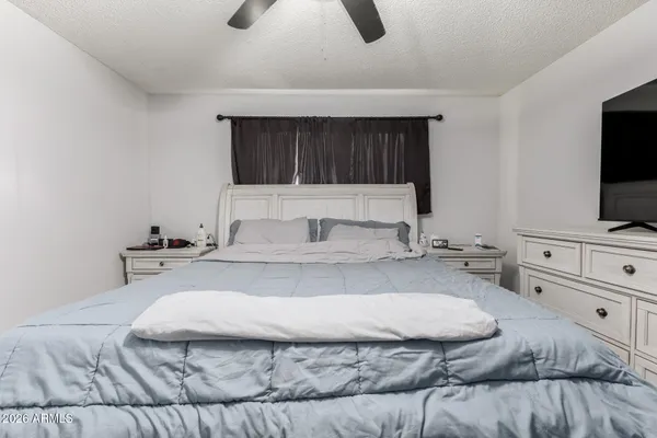 a spacious bedroom with a bed and flat screen tv